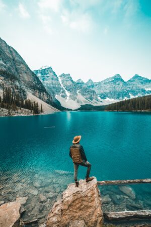 Man Standing on Rock Near Lake in Alberta and Rocky Mountains | Luxury Canada Holidays | The Ultimate Travel Company