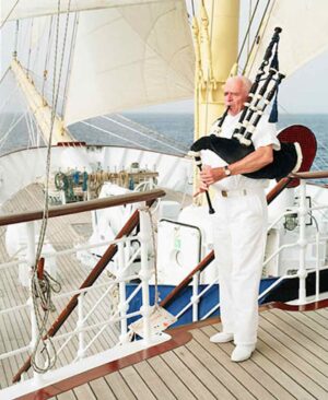 Star Clipper, Italy | Man in white playing bagpipes on a ship deck | The Ultimate Travel Company