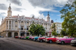 Havana | Classic cars lined up in front of the ornate architecture of the Great Theatre of Havana | The Ultimate Travel Company
