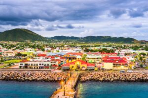 Nevis | Coastal town with pier and mountainous backdrop | The Ultimate Travel Company