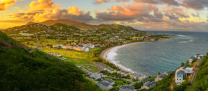 Nevis | Panoramic view of a seaside town at sunset | The Ultimate Travel Company