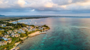 Jamaica | An aerial view of a coastal village with boats and clear waters | The Ultimate Travel Company