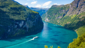 A Cruise Ship Riding Along Blue Waters and Mountain Landscapes | Luxury Tailor-Made Holidays | The Ultimate Travel Company
