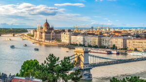 Hungary | Panaromic view of Budapest City with the bridge and boats passing by | The Ultimate Travel Company