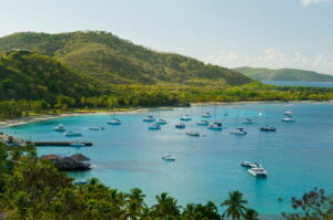 Mustique | Scenic view of a bay with yachts and lush hills | The Ultimate Travel Company