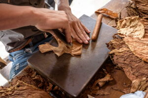 Vinales And Cayo Levisa | Person hand-rolling a cigar with tobacco leaves | The Ultimate Travel Company