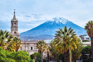 Arequipa & Colca Canyon | Church steeple and palm trees against a backdrop of a snow-capped volcano | The Ultimate Travel Company