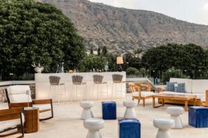 Blue Palace, Elounda, Crete | Greece | Outdoor bar seating with mountain backdrop | The Ultimate Travel Company