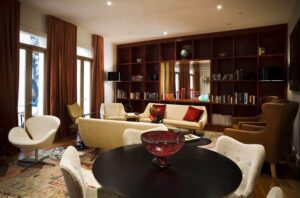 Hotel Debrett, Auckland | Elegant interior of a drawing room with a bookshelf, comfortable seating, and warm lighting | New Zealand | The Ultimate Travel Company
