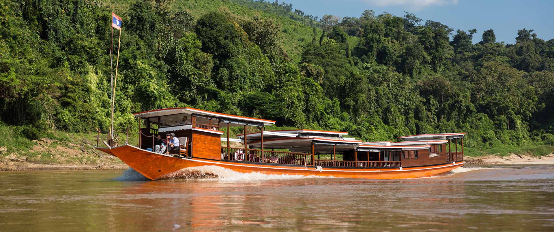 Luang Say River Cruise | Traditional riverboat cruising on a tropical river | The Ultimate Travel Company
