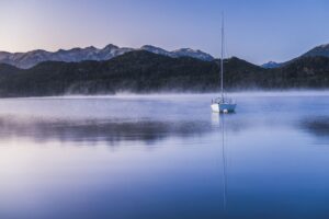 Sailing boat on a misty sunrise at Nahuel Huapi Lake, Villa la Angostura, Neuquen, Patagonia, Argentina