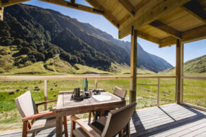 Minaret Station, New Zealand | Deck with table overlooking mountains | The Ultimate Travel Company