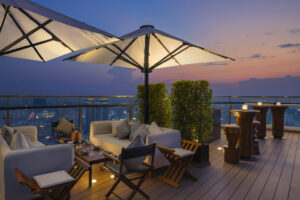 Rosewood Phnom Penh | Cambodia | Rooftop terrace with seating and city skyline at dusk | The Ultimate Travel Company