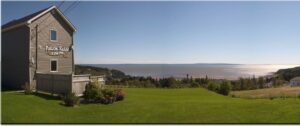 Falcon Ridge Inn, Fundy Bay | Canada | A panoramic view of Falcon Ridge Inn overlooking a vast bay and lush greenery | The Ultimate Travel Company