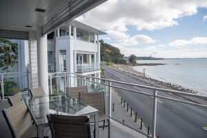 The Waterfront Suites, Bay Of Island | View from a balcony overlooking a calm bay with an island | New Zealand | The Ultimate Travel Company