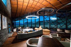 The Lindis, Ahuriri Valley | Interior of a modern lounge at night with circular lighting and mountain views | The Ultimate Travel Company
