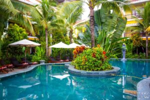 La Siesta Hoi An Resort & Spa | Hoi An | Tropical pool oasis with umbrellas and lush foliage | The Ultimate Travel Company