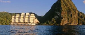 Star Clipper, Italy | Sail ship near a lush mountain at sunset | The Ultimate Travel Company