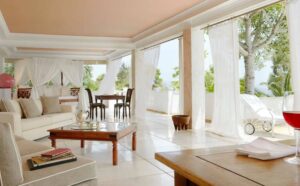 Danai Resort, Halkidiki | Greece | Elegant living room with terrace access and a glass of wine on the table | The Ultimate Travel Company
