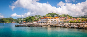 Grenada | Coastal town with colorful buildings and boats in a clear blue harbor | The Ultimate Travel Company