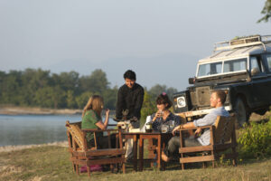 Tiger Tops Karnali Lodge, Bardia National Park | Nepal | tourist eating beside the lake | The Ultimate Travel Company