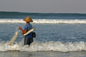 A Man Fishing in the Waves | Indonesia Holidays | The Ultimate Travel Company