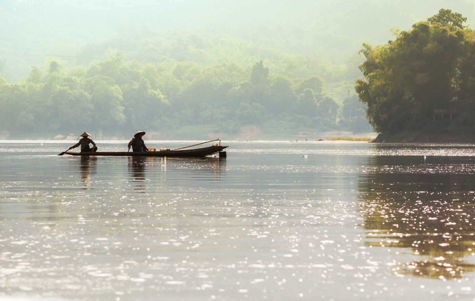 Two People on a Boat on the River in Laos | Luxury Laos Holidays | The Ultimate Travel Company
