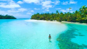 A Woman Walking in the Turquoise Waters of the Cook Islands | Luxury Cook Island Holidays | The Ultimate Travel Company