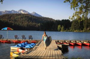 Tyax Wilderness Resort & Spa, Southern Chilcotin Mountains | British Columbia | Woman holding a paddle board | The Ultimate Travel Company