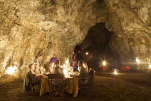 Campi Ya Kanzi, Chyulu Hills | Kenya | Inside the cave families eating dinner together | The Ultimate Travel Company