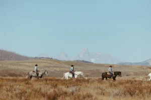 Three People Horse Riding Across the Wild West in Wyoming at the Goosewing Ranch | Ranch Holidays in the USA | The Ultimate Travel Company