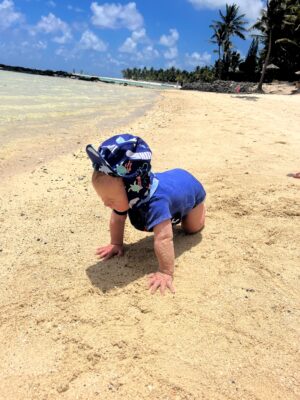 baby playing in the sand and the sea